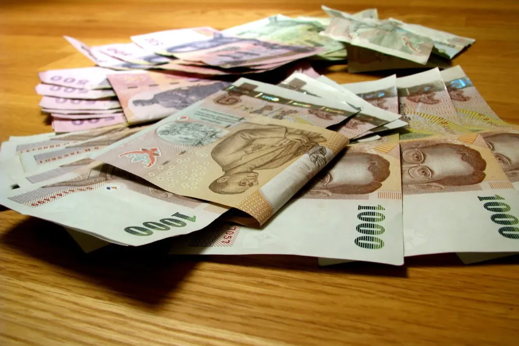 Thai baht banknotes and coins used for daily spending without a DTV visa bank account
