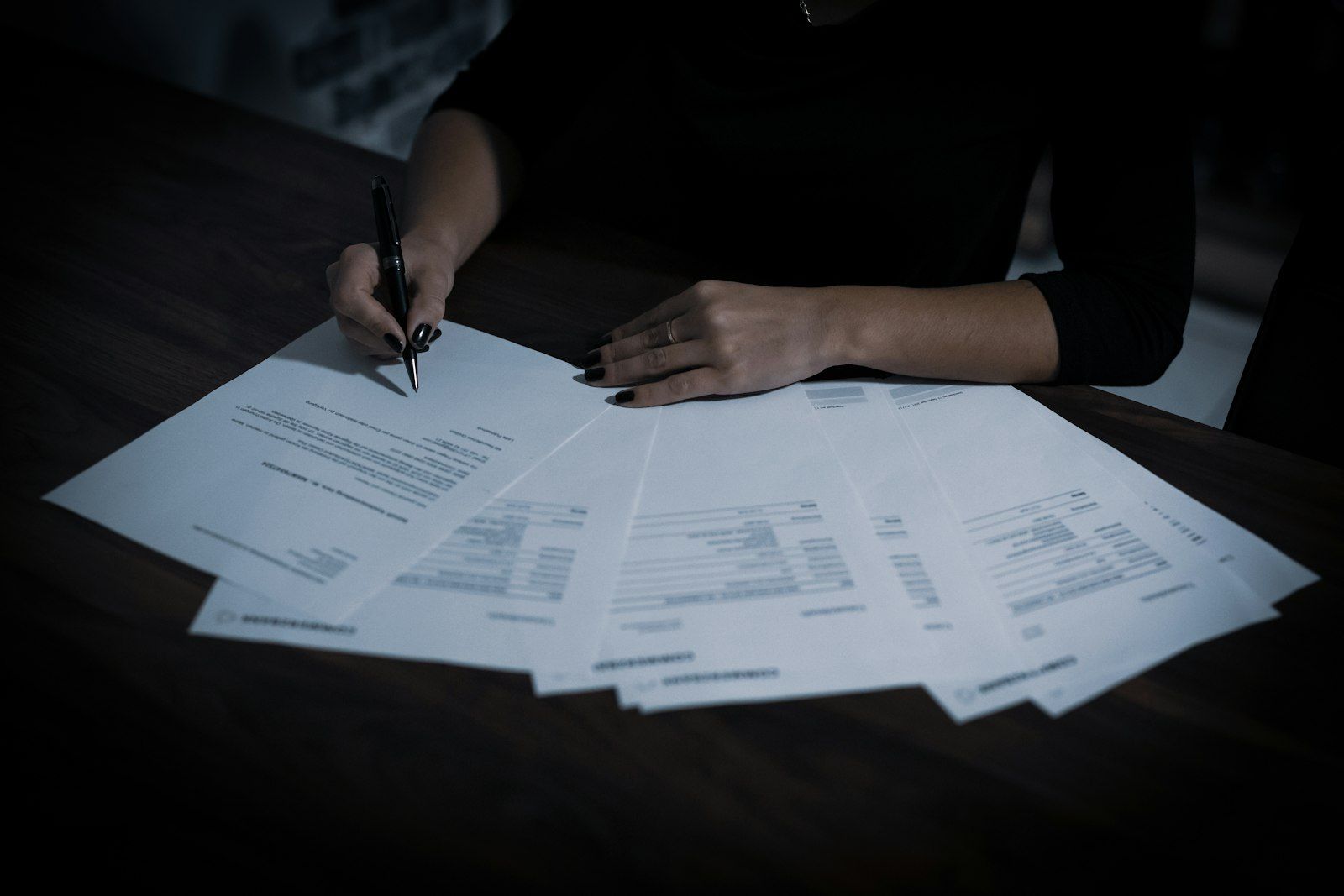 A person working through business paperwork and legal documents at a desk