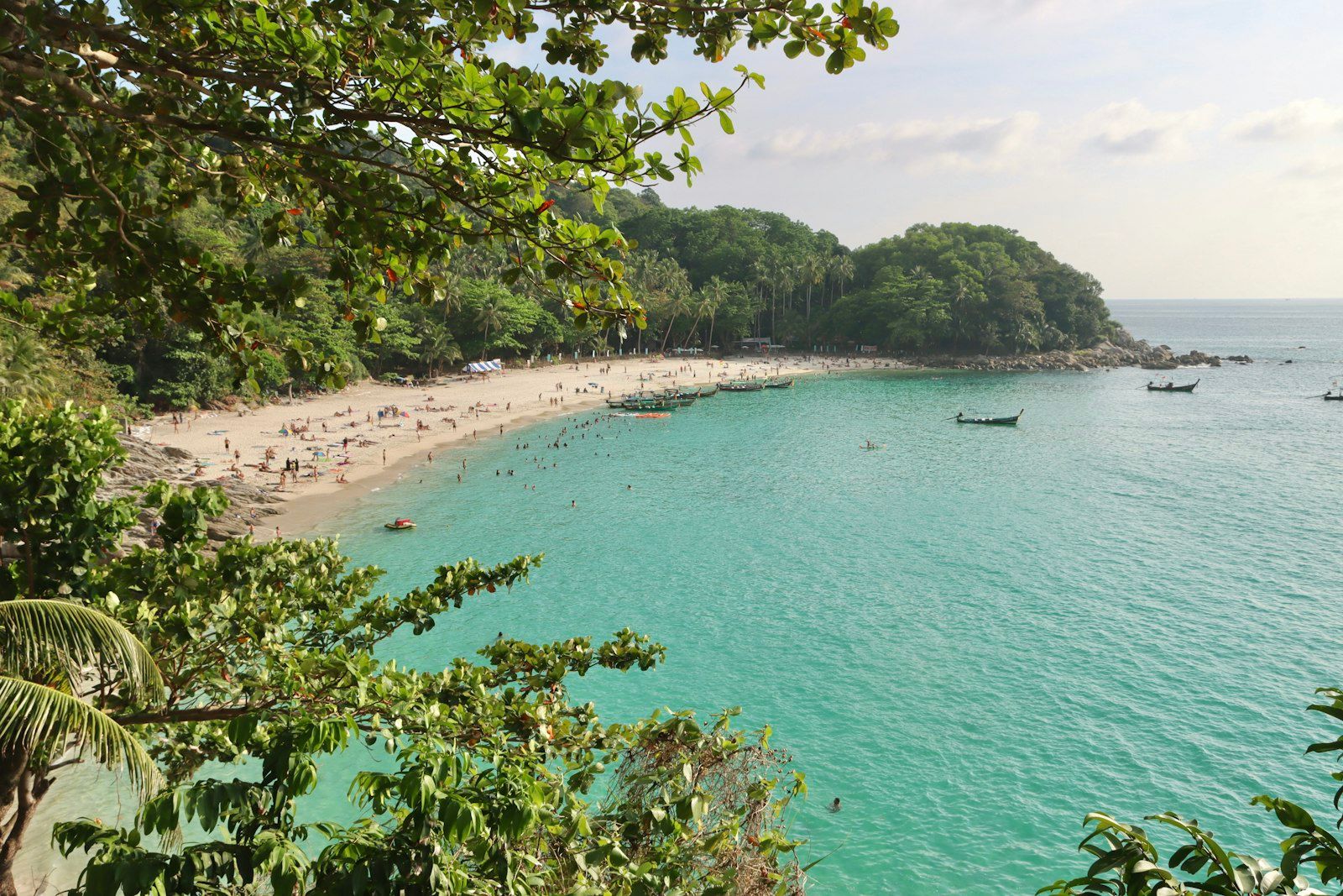 A busy Phuket beach with longtail boats and sunbeds, the developed Andaman coast