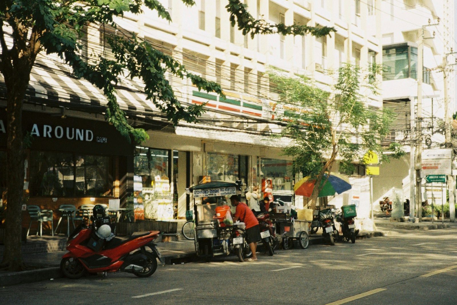 A row of scooters and motorbikes parked on a Phuket street outside a rental shop