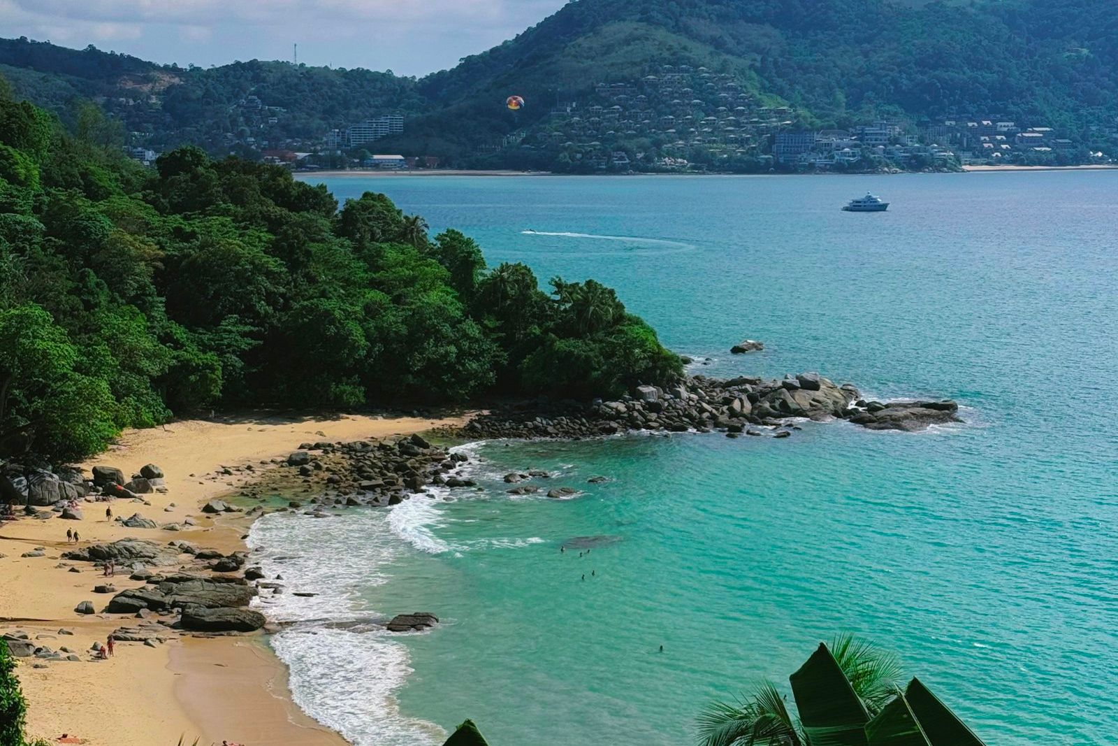 Phuket-Strand in der trockenen Hauptsaison mit ruhiger Andamanensee und Bergkulisse