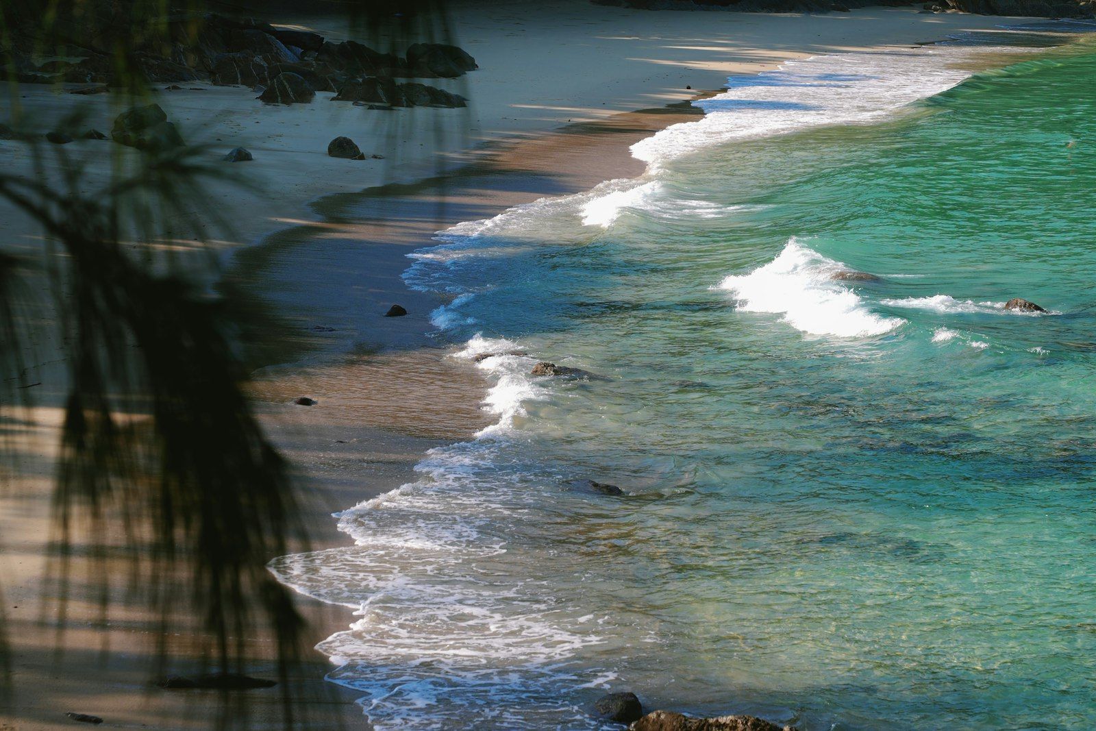 Waves rolling onto the sand at Patong Beach Phuket, where swimming is safe in high season