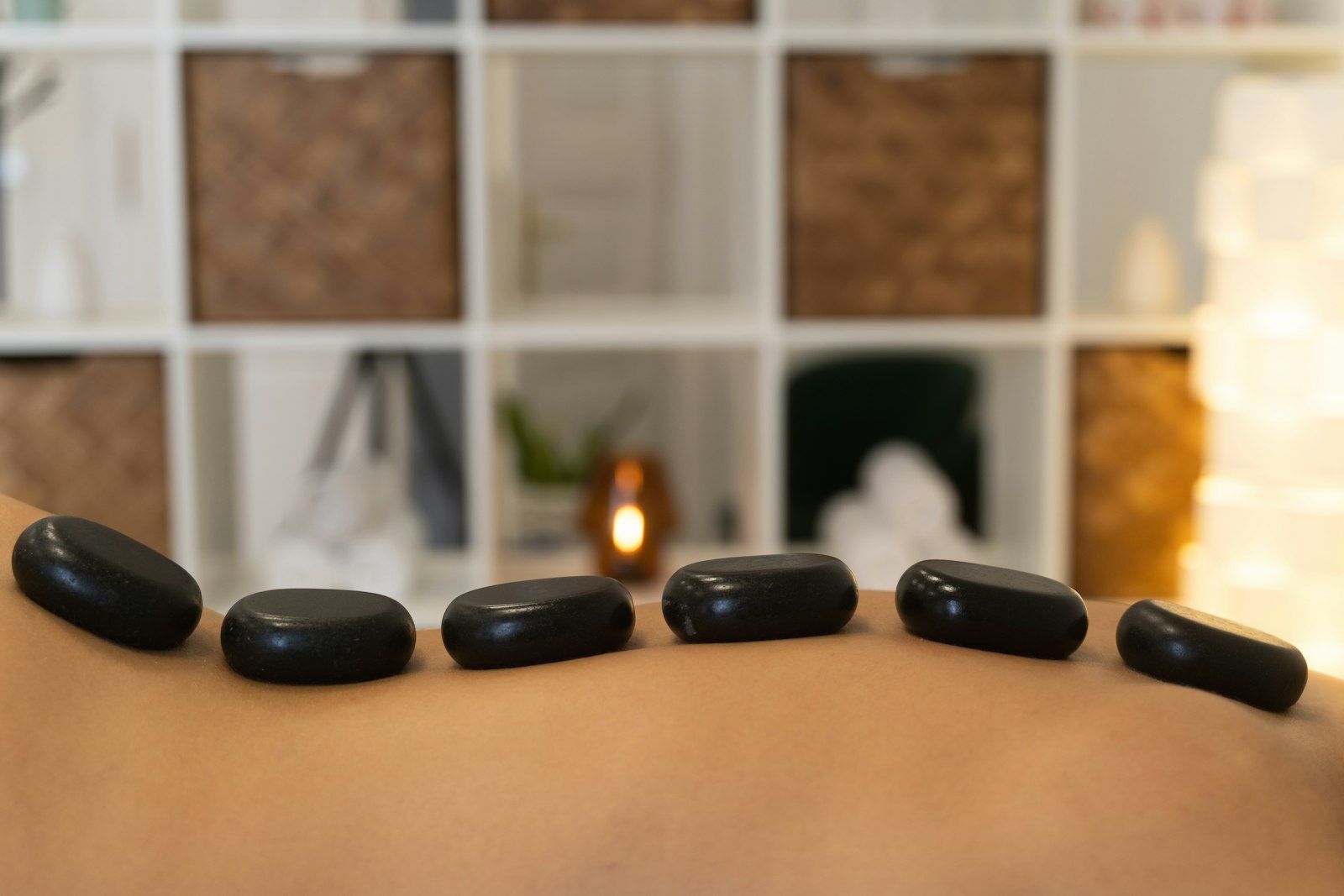 Hot stones on a person's back at a Thai spa, part of Thailand's traditional treatment culture