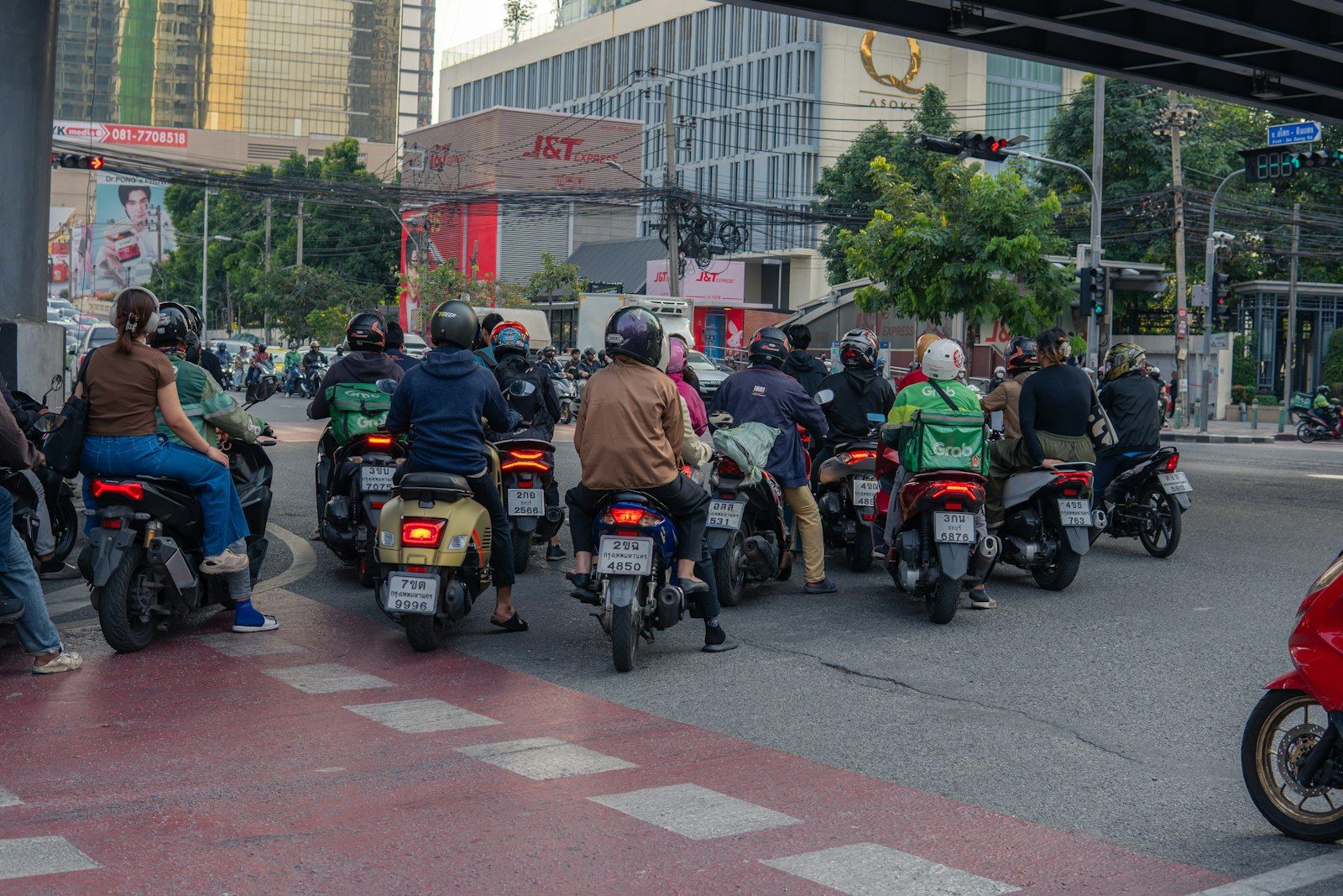 Motorbikes and cars waiting at a busy Thai city intersection where police checkpoints are common