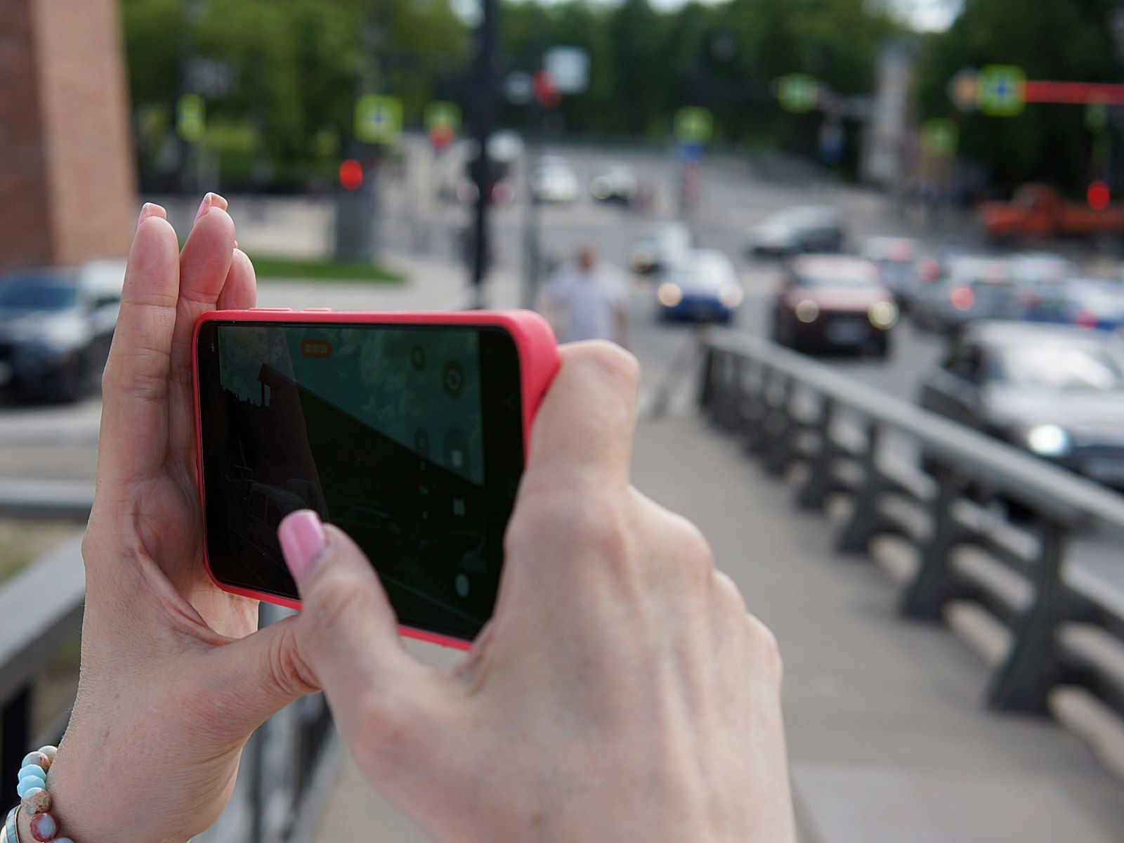 A person openly recording a street scene on a smartphone