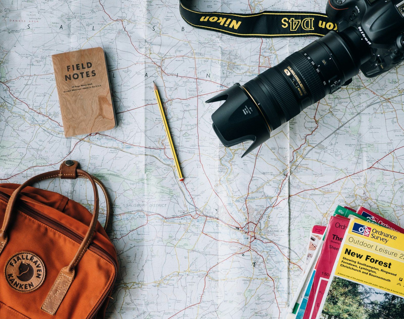 Map, notebook and travel documents laid out to plan a Destination Thailand Visa application