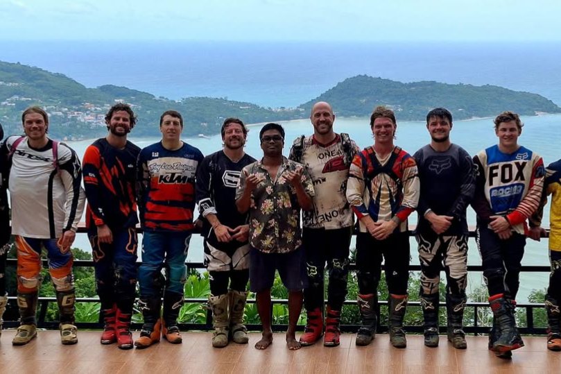 Group of enduro riders in gear at a hilltop viewpoint above the coast, from the Enduro in Phuket off-road guide