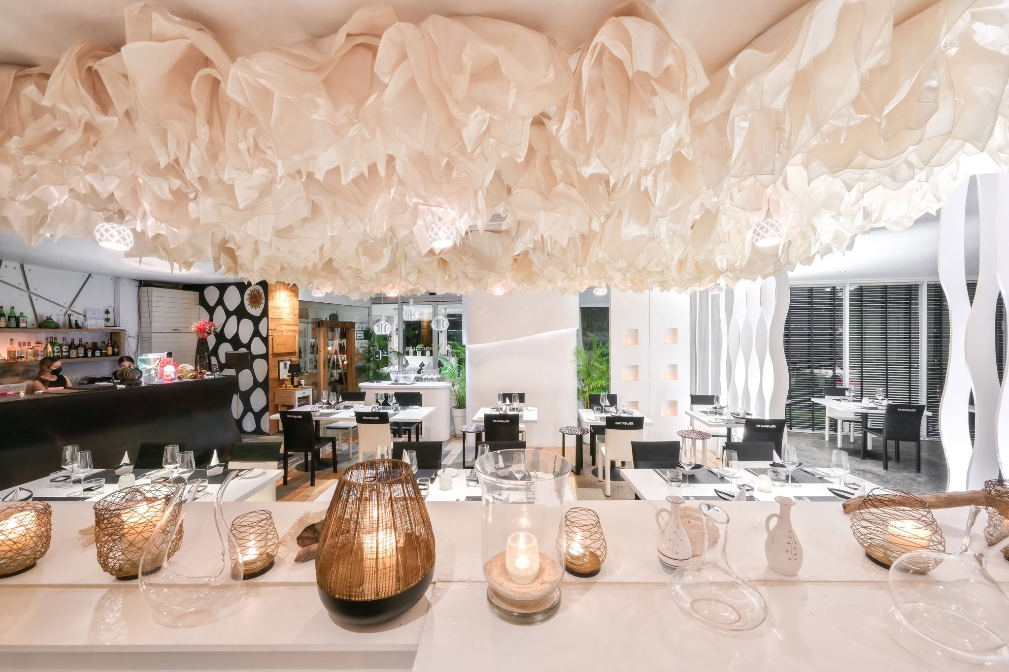 Elegant dining room with draped fabric ceiling and set tables at Acqua, an Italian restaurant in Patong, Phuket