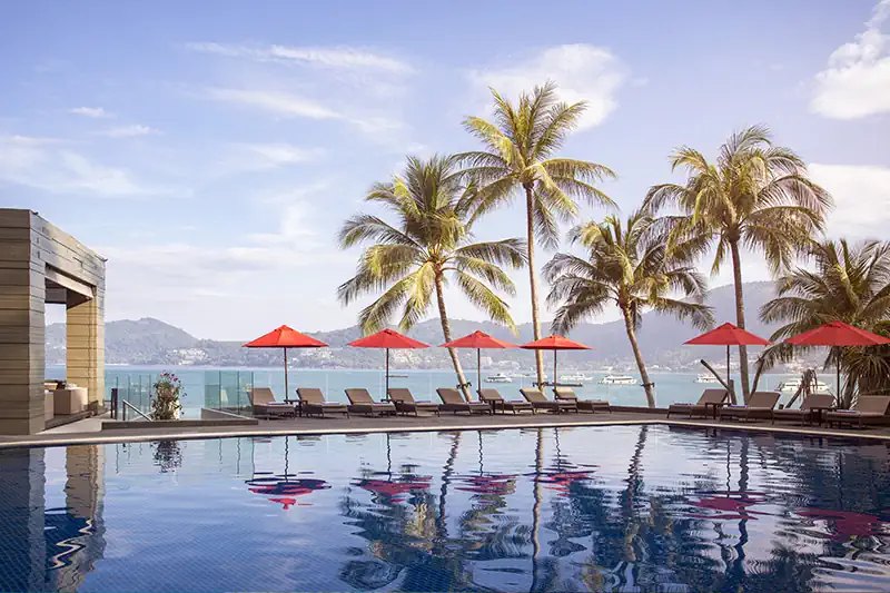Beachfront pool with red parasols at Amari Phuket, Patong