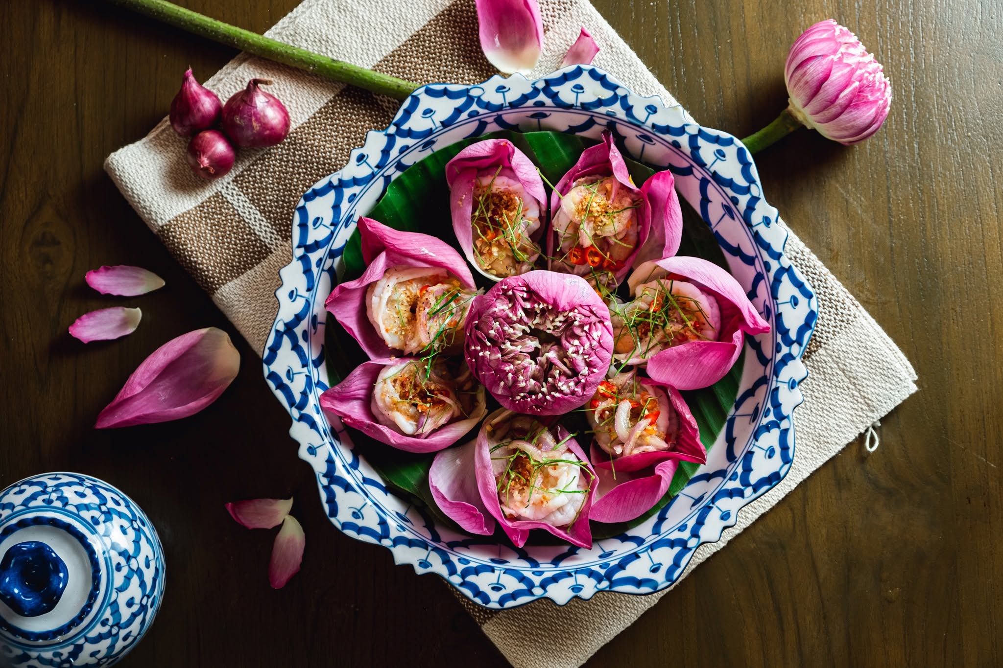 Shrimp served in pink lotus petals on a blue and white Thai plate at Bucha, a Southern Thai restaurant in Chalong, Phuket