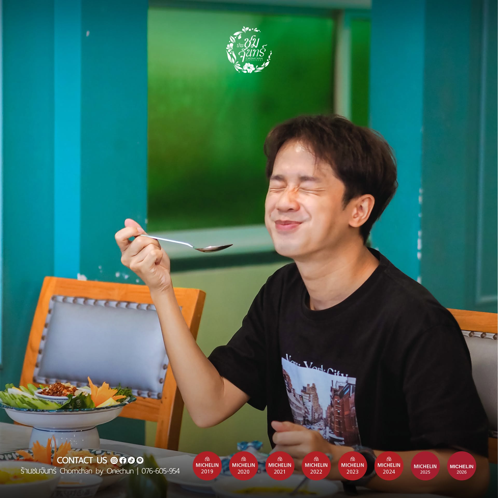 Smiling diner tasting Southern Thai food at Chom Chan, a MICHELIN Selected restaurant in Phuket Old Town