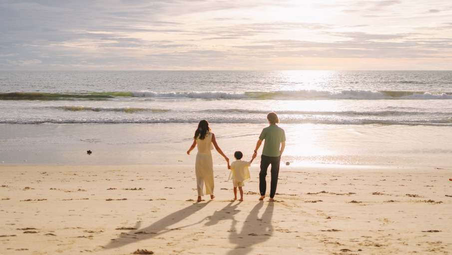 Family walking on Bang Tao Beach at sunset at Dusit Thani Laguna Phuket