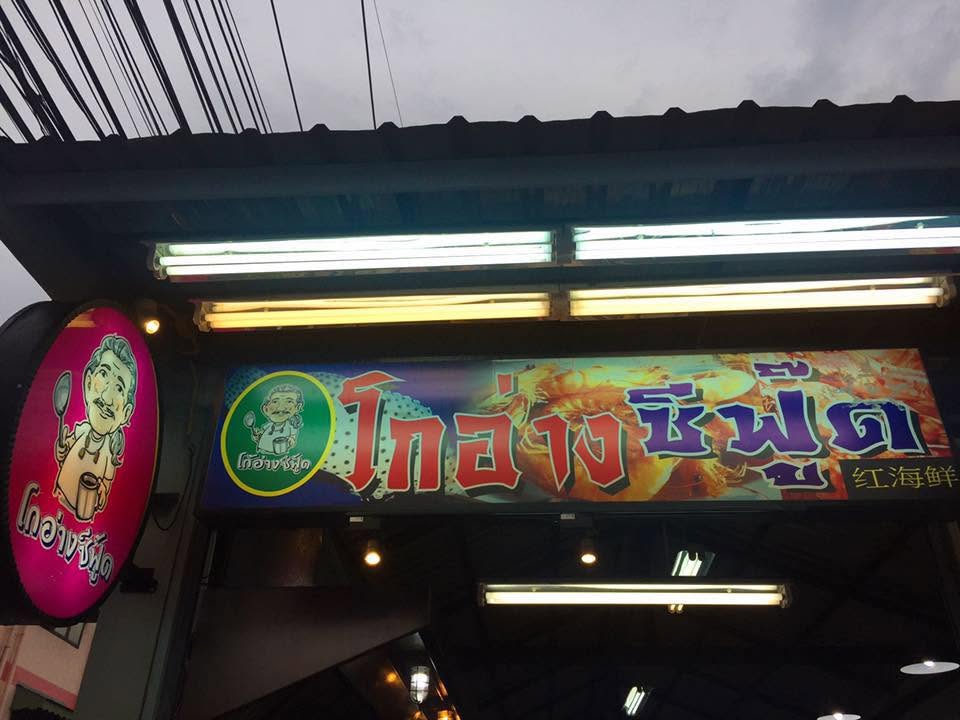 Illuminated Go Ang Seafood shopfront sign with chef logo and shrimp graphics at dusk, Old Town Phuket