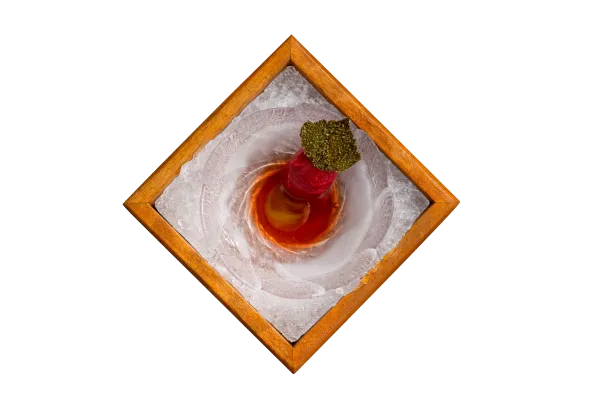 Overhead view of a plated course served on ice in a wooden diamond frame at hom modern cuisine restaurant in Kamala, Phuket