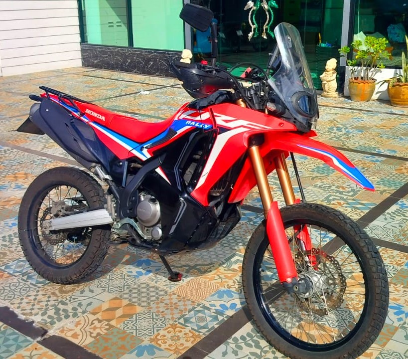 Red Honda CRF Rally dual-sport motorcycle parked on patterned tiles at Phuket CRF Off-Road & Enduro Rentals in Patong, Phuket.