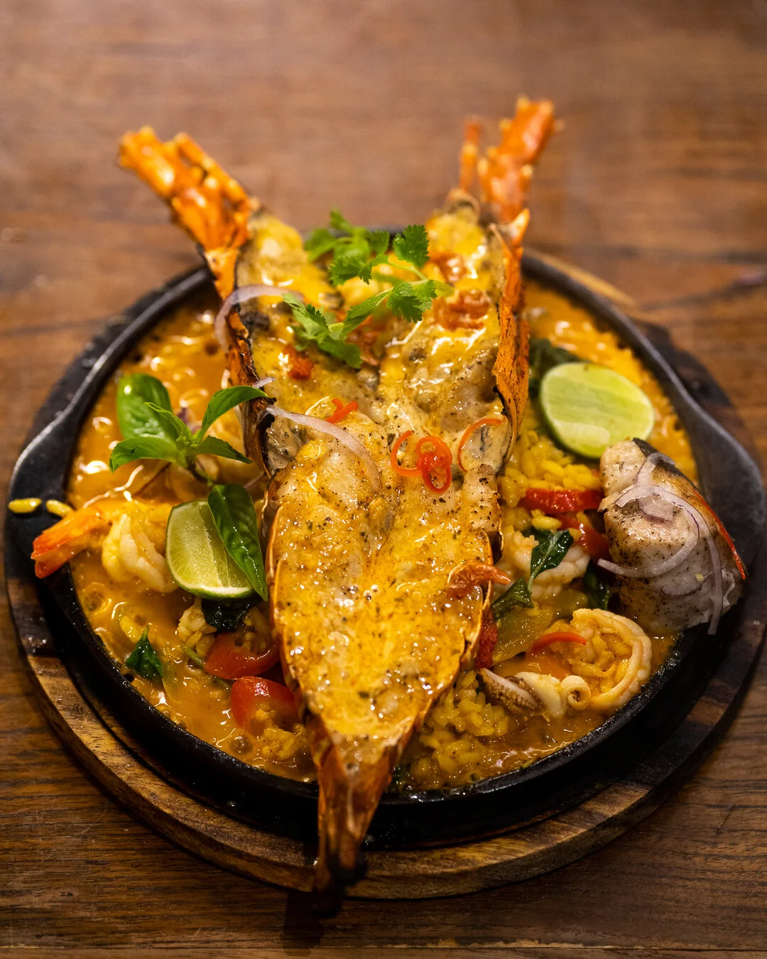 Sizzling plate of grilled prawns, squid and curry rice with lime and basil at Suay, a Thai restaurant in Bang Tao, Phuket