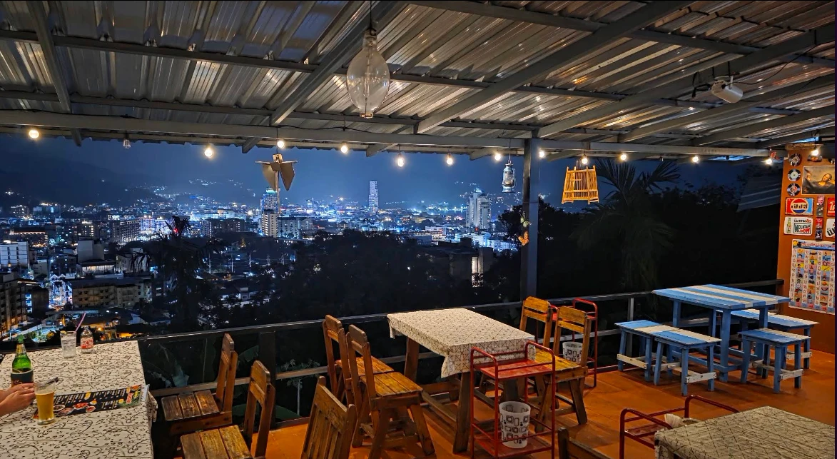 Rooftop terrace with string lights over Patong's night city lights at Ta Yong Garden Cafe, a Thai hillside cafe in Phuket