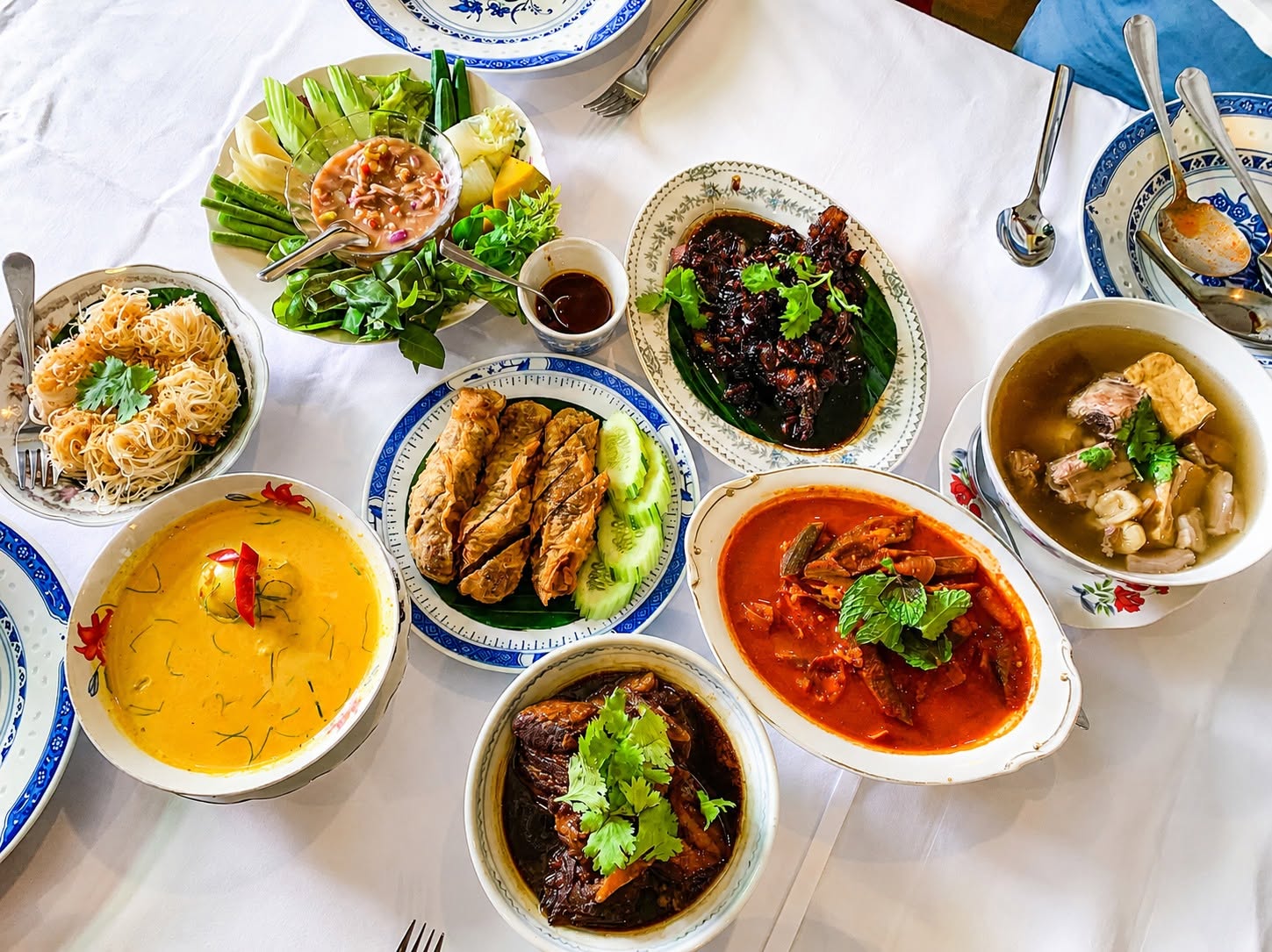 Overhead spread of Southern Thai dishes including curries, spring rolls and soup at The Charm Dining Gallery in Old Town, Phuket