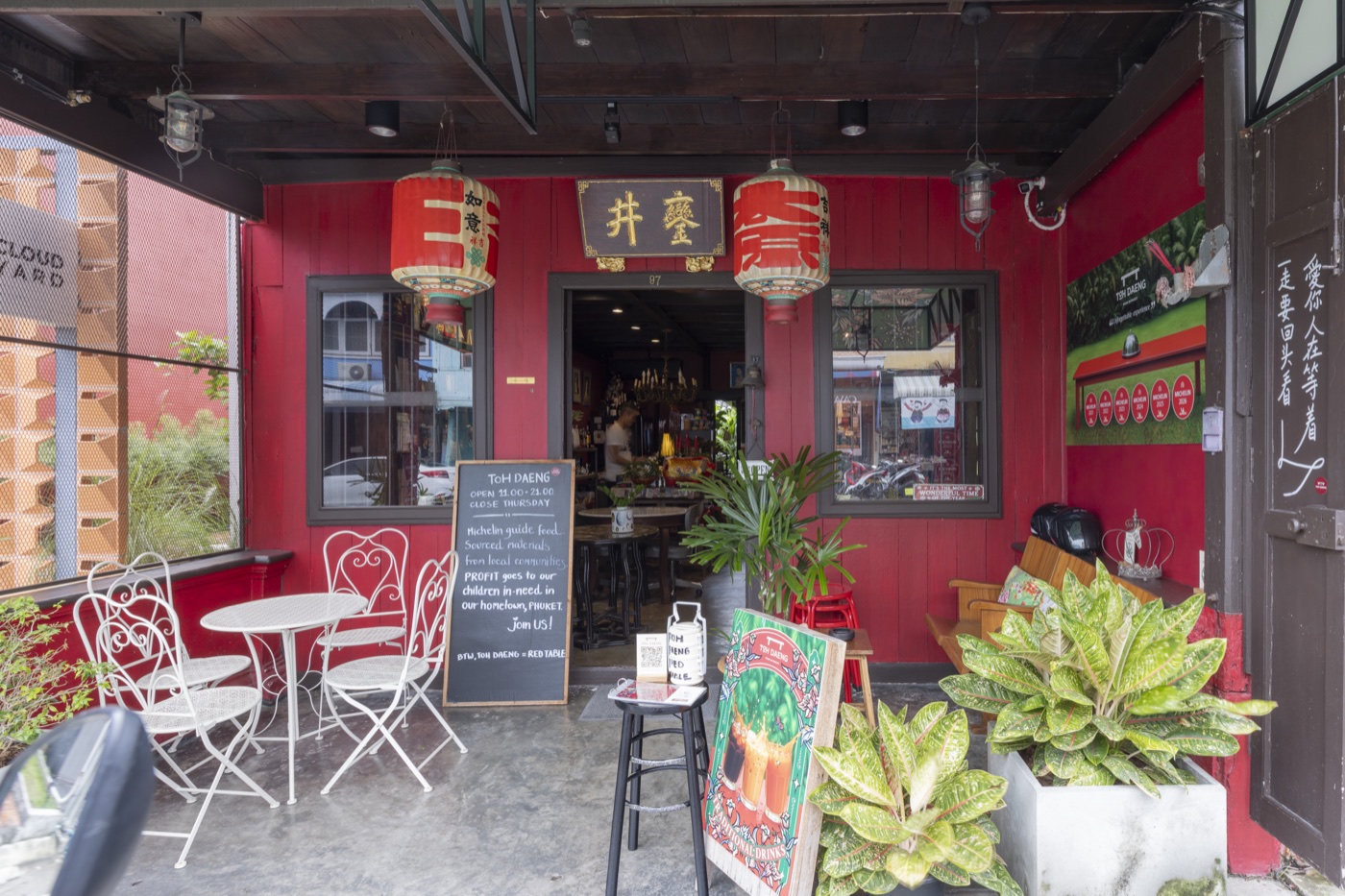 Red timber shopfront with Chinese lanterns and bistro tables at Toh Daeng, a Thai restaurant in Bang Tao, Phuket