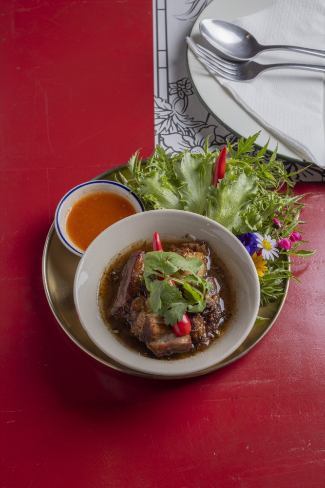 Bowl of braised pork belly with cilantro, fresh greens and dipping sauce at Toh Daeng, a Thai restaurant in Bang Tao, Phuket